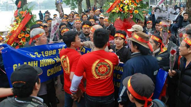 Nhóm thanh niên mặc áo đỏ ngăn cản người dân đặt vòng hoa trước tượng đài Lý Thái Tổ để tưởng niệm các chiến sĩ đã hy sinh trong trận hải chiến Gạc Ma ngày 14/3/2015.