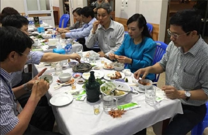 Bộ trưởng Y tế Nguyễn Thị Kim Tiến(áo xanh) ăn hải sản tại Hà Tĩnh hôm 1-5-2016. Ảnh: Facebook