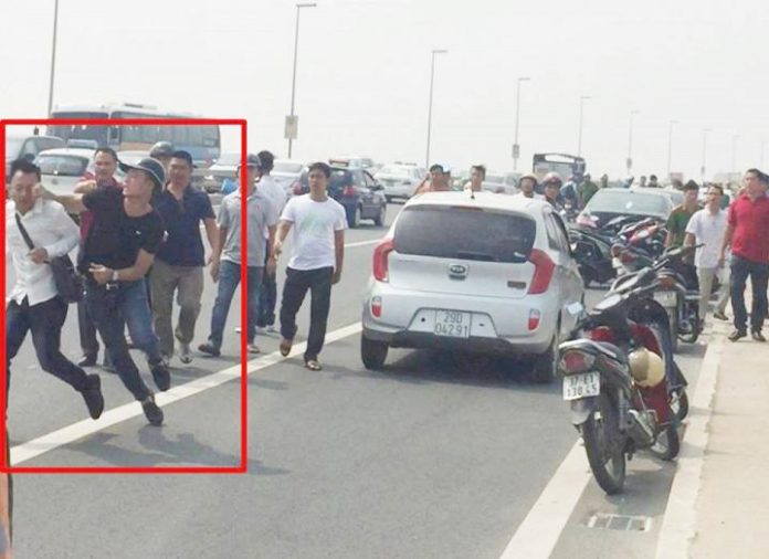 Hình cảnh sát hình sự Ngô Quang Hưng đánh phóng viên Trần Quang Thế đang thu tin ở cầu Nhật Tân, Hà Nội