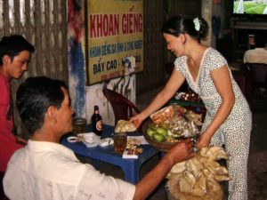 Dân Việt kêu trời vì các chính sách kiểu 'trời ơi' Một phụ nữ nhập cư, kiếm sống bằng nghề bán dạo quanh các quán nhậu vỉa hè. (Hình: Văn Lang/Người Việt)