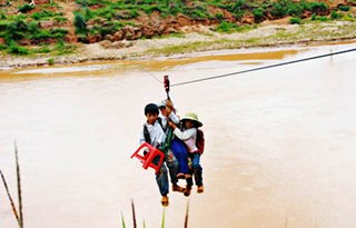 Hình ảnh các em học sinh đu dây qua sông để đến trường. Ảnh: Internet