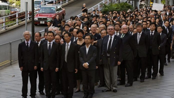 Hơn 1.000 luật sư Hong Kong trong trang phục màu đen tuần hành trong im lặng qua các đường phố hôm 27/6/2014 để phản đối Trung Quốc toan tính can thiệp vào tính độc lập của nền tư pháp Đặc Khu Hong Kong. Ảnh FB Trịnh Vĩnh Phúc/AP