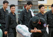 Một cảnh sát lạy tạ dân làng Đồng Tâm hôm 22 tháng Tư sau khi được phóng thích. (REUTERS/Kham)