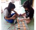 Nguyễn Thị Quỳnh Trâm (trái) và Nguyễn Thị Ngọc Nhung đang chế tạo áo phao từ chai nhựa. Ảnh: Báo Gia Lai.