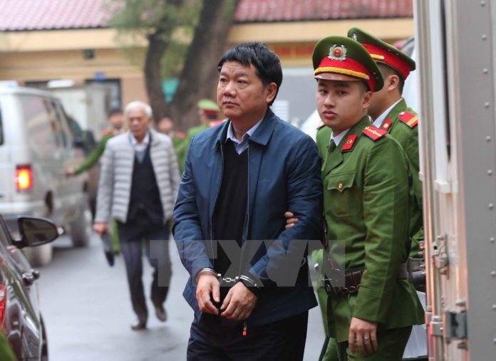 Cảnh sát áp tải bị cáo Đinh La Thắng đến tòa án.
