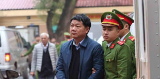 Cảnh sát áp giải ông Đinh La Thắng đến tòa. Ảnh: vietnamnet