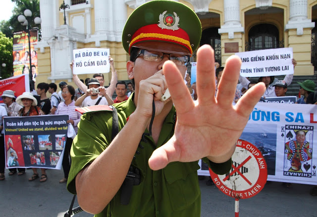 Một nhân viên cảnh sát cấm người chụp ảnh trong một cuộc biểu tình chống Trung Quốc bên ngoài Nhà hát lớn Hà Nội hôm 22/7/2012. Ảnh: Reuters/Nguyen Lan Thang